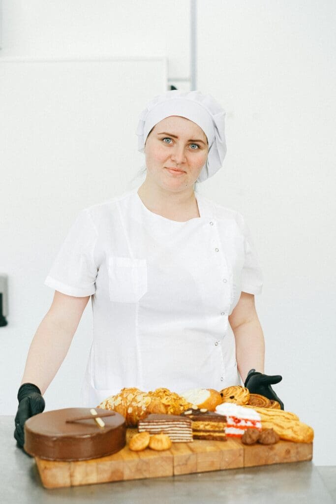 pexels-photo-5964621-5964621 Pastry chef in uniform presenting a variety of freshly baked pastries.